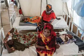  ?? ?? Jamia Ishak Osman sits with her baby and daughter, who has malaria, at a clinic in Adre camp, Chad. Africa accounts for 96% of global malaria deaths. Photograph: Abdulmonam Eassa/Getty