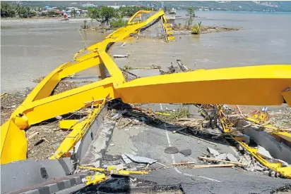  ??  ?? Tangled and twisted... the wrecked remains of a bridge in Palu yesterday, cutting off links to nearby towns
