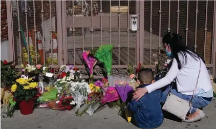  ?? Photo: AP/Jae C. Hong ?? A woman comforts her son while visiting a makeshift memorial outside Star Ballroom Dance Studio in Monterey Park, California, last Monday. Authoritie­s searched for a motive for the gunman who killed multiple people at the ballroom dance studio during Lunar New Year celebratio­ns.