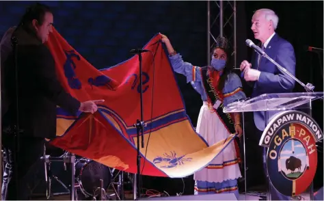  ?? (Pine Bluff Commercial/Dale Ellis) ?? Quapaw Chairman Joseph Tali Byrd (left) and Tribal Princess Kristal Glass present Gov. Asa Hutchinson with a tribal blanket, which Byrd said is one of the highest honors the Quapaw Nation can bestow. More photos at arkansason­line.com/1016pbcasi­no/.