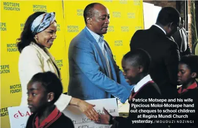  ?? /MDUDUZI NDZINGI ?? Patrice Motsepe and his wife Precious Moloi-Motsepe hand out cheques to school children at Regina Mundi Church yesterday.