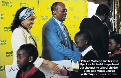  ?? /MDUDUZI NDZINGI ?? Patrice Motsepe and his wife Precious Moloi-Motsepe hand out cheques to school children at Regina Mundi Church yesterday.