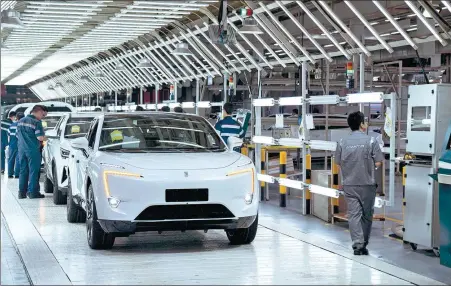  ?? LI QIANLEI / XINHUA ?? Employees work on the production line of Changan’s premium Avatr marque in Chongqing.