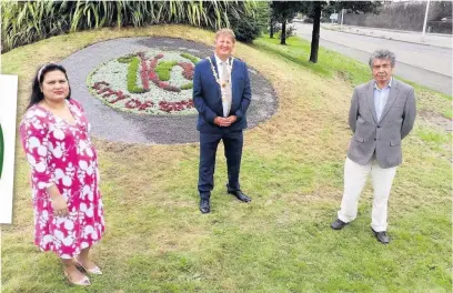  ??  ?? Lord Mayor Cllr Mark Child, centre, unveils the Swansea City of Sanctuary tenth anniversar­y flower display with Swansea City of Sanctuary co-chair Amber Esther and Swansea resident Jose Cifuentes who came to the city seeking safety from Chile.