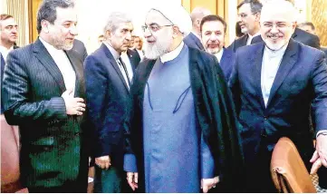  ??  ?? Rouhani (centre) arriving for a meeting with foreign ministry officials in the capital Tehran, accompanie­d by Foreign Minister Mohammad Javad Zarif (right). — AFP photo