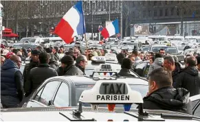  ?? Reuters ?? Parked: Striking taxi drivers attending a protest against competitio­n from ride-hailing app firms like Uber in Paris. —