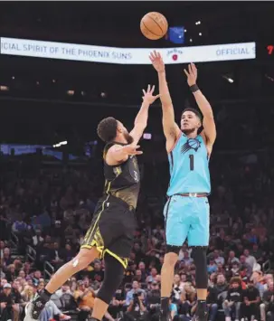  ?? AFP ?? Devin Booker of the Phoenix Suns launches a 3-pointer over Stephen Curry of the Golden State Warriors during Wednesday’s NBA game at Footprint Center in Phoenix, Arizona. Booker finished with 27 points as all five Suns starters scored in double figures in a 130-119 victory.