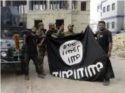  ?? (Reuters) ?? IRAQI FORCES hold an Islamic State flag they captured during a battle on July 26.