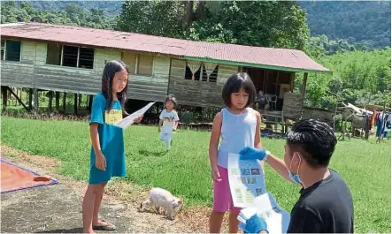  ??  ?? Dedication to service: Nazmi delivering homework to students in a remote village in Sarawak.