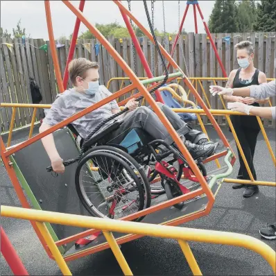  ??  ?? SWINGING TIMES: Gregor Marshall with his mum Karen as Gregor has a ride on the wheelchair swing in the outside therapy area.