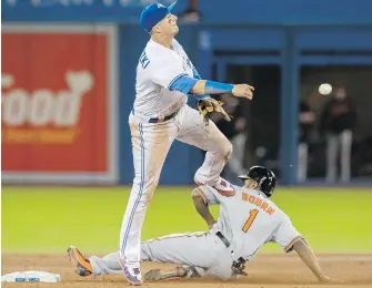  ??  ?? Blue Jays shortstop Troy Tulowitzki turns a double play over Orioles base runner Michael Bourn during the ninth inning in Toronto on Tuesday.