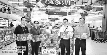  ??  ?? Charles Sii ( second from right), with three other staff holding boxes of Lo Kam.