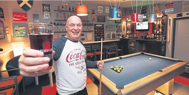  ?? Pictures: Mhairi Edwards. ?? Dundee man Steve Keillor, 50, toasts the success of his self-made ‘man cave’ which has beer bucket light shades and drink-related signs and slogans.