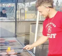  ?? Jeff Larson/appeal-democrat ?? A concession worker works the grill during a Gold Sox game. Concession­s manager Emily Smoot checks in with her customers during Thursday’s home game.