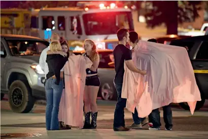  ?? — AP ?? People comfort each other as they stand near the shooting scene on Thursday in Thousand Oaks, California.