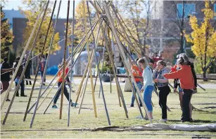  ??  ?? There are many support poles and angles to reckon with while raising a teepee. These students were taking part in the Glen Anaquod Memorial Tipi Raising Competitio­n on Friday.