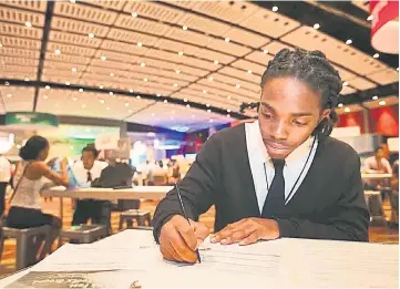  ??  ?? Youth filling out job applicatio­ns at Opportunit­y Fair and Forum at McCormick Place Chicago, Illinois. Equal opportunit­ies in the US are now scarce.