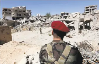  ?? Louai Beshara / AFP / Getty Images ?? Syrian government forces patrol the previously rebel-held Jobar district of eastern Ghouta outside the capital. Rebel fighters evacuated to Jarablus, a town in northern Syria.