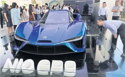  ??  ?? Visitors look at the Nio EP9, an electric-powered two-seated supercar manufactur­ed by NIO during a promotion event at a shopping mall in Beijing yesterday.