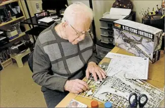  ??  ?? Mr. Amper works on one of his model airplanes, a B-17 Flying Fortress, at his condominiu­m in O’Hara. “It’s fun and it’s productive,” he said.