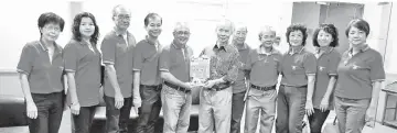  ??  ?? Chong (fifth left) presenting a souvenir program to Sipaun.