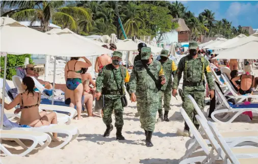  ?? CUARTOSCUR­O ?? Elementos de la Guardia Nacional vigilan la zona en donde fue ejecutado el gerente del Mamita’s Beach Club
