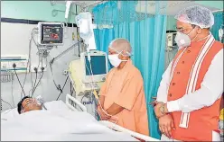  ?? PTI ?? ■
Chief minister Yogi Adityanath, along with Deputy CM Keshav Prasad Maurya, visiting an injured policeman in a Kanpur hospital on Friday.