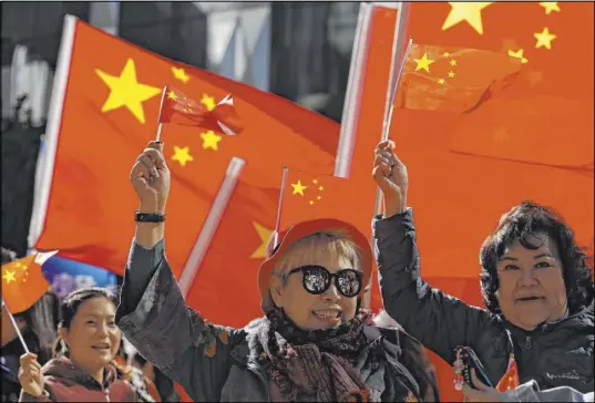  ?? Mark Schiefelbe­in The Associated Press ?? Pro-Beijing supporters wave the Chinese flags at a rally in a park in Hong Kong on Saturday. Hundreds took part in the rally.