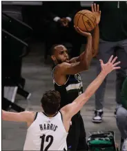  ?? (AP/Jeffrey Phelps) ?? Milwaukee forward Khris Middleton shoots over Brooklyn forward Joe Harris (12) on Thursday during the Bucks’ 104-89 victory over the Nets in Milwaukee. Middleton scored a game-high 38 points for the Bucks, who forced a Game 7 in their NBA Eastern Conference semifinal series Saturday.