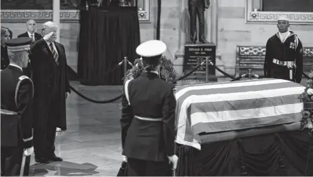  ?? Karen Warren / Staff photograph­er ?? President Donald Trump salutes the coffin of former President George H.W. Bush on Monday at the Capitol Rotunda. The president missed the bipartisan ceremony held earlier in the day but spent a few minutes that night to pay his respects.