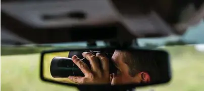  ?? Michael Ciaglo / Houston Chronicle ?? Texas Game Warden Dustin Dockery uses his binoculars to watch suspicious activity near Anahuac.