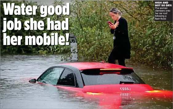  ??  ?? HIGH AND NOT SO DRY: The woman clambers onto her car roof following a flash flood