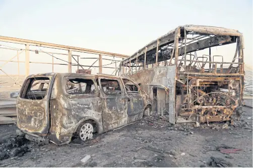  ?? AFP ?? Vehicles are burned out after gunmen and suicide car bombers killed dozens of people in two assaults claimed by IS jihadists near the Iraqi city of Nasiriyah on Thursday.
