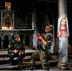  ??  ?? AMID THE RUINS: Iraqi Christian soldiers inside the Grand Immaculate Church in Qaraqoshm near Mosul. It was recaptured from Isil fighters in late 2016