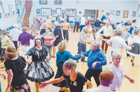  ??  ?? Couples square dance at Maple Grove Grange in Denver on July 14.