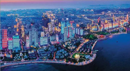  ?? PHOTOS PROVIDED TO CHINA DAILY ?? The city of Qingdao lights up at night, creating a colorful spectacle on the coast.