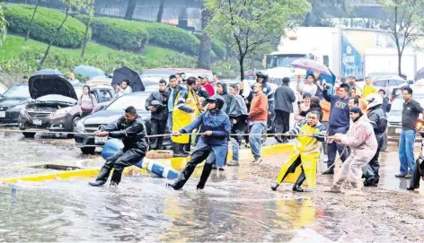  ??  ?? Personal de tránsito de la Secretaría de Seguridad Pública de la Ciudad de México rescató a diversas personas que quedaron atrapadas dentro de sus vehículos inundados, esto en el cruce de las avenidas Circuito Interior y Reforma.