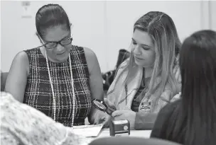  ?? LYNNE SLADKY/ASSOCIATED PRESS ?? Canvassing board members Tanya Brinkley, left, and Victoria Ferrer verify signatures on mail-in ballots at the Miami-Dade County Elections Department on Tuesday.