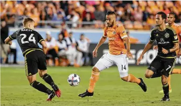  ?? Yi-Chin Lee / Houston Chronicle ?? El mediocampi­sta brasileño Alex (14) controla la pelota frente a la marca de Nicolai Naess (24) y Artur (7) durante el triunfo 3-1 del Dynamo sobre Columbus Crew en el BBVA Compass Stadium de Houston.