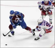  ?? ANDY CROSS — THE DENVER POST ?? Avalanche center Nathan Mackinnon, left, and Rangers center Alex Wennberg chase down the puck during the second period at Ball Arena in Denver on Thursday.
