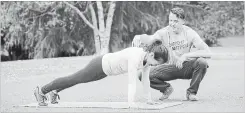  ??  ?? Nicole Tsong works with trainer Kyle Long on plank movements to begin a crawling and locomotion workout.