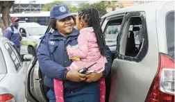  ?? PICTURE: DAVID RITCHIE/AFRICAN NEWS AGENCY (ANA) ?? SAFE: Traffic officer Nontsikele­lo Kalimani holds the girl, 3, rescued from a locked vehicle on Grand Parade.