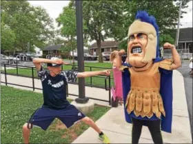  ??  ?? Pottstown High School senior Nate Camacho matches moves with Trojan Man during a visit to Rupert, his neighborho­od elementary school.