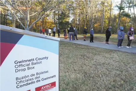  ?? Tami Chappell / AFP / TNS 2020 ?? Voters wait in line to cast their ballots in Atlanta during early voting Dec. 14 in Georgia’s U.S. Senate runoff elections.