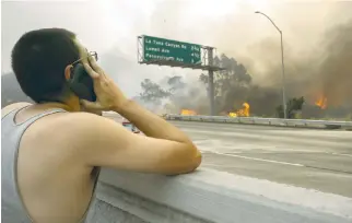  ??  ?? A man watches to see if his house on the other side of thick smoke and flames might burn near the community of Tujunga during the La Tuna Fire on Saturday near Burbank, California. (AFP)