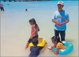  ?? ?? A la izquierda, Héctor Celis con sus hijos a la orilla del mar en Sisal. Abajo, la entrada del muelle, por ahora sin letras turísticas