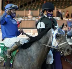  ?? Michael Conroy The Associated Press ?? Jockey Luis Saez and last year’s juvenile champion, Essential Quality, are led into the winner’s circle after one of the horse’s five wins.