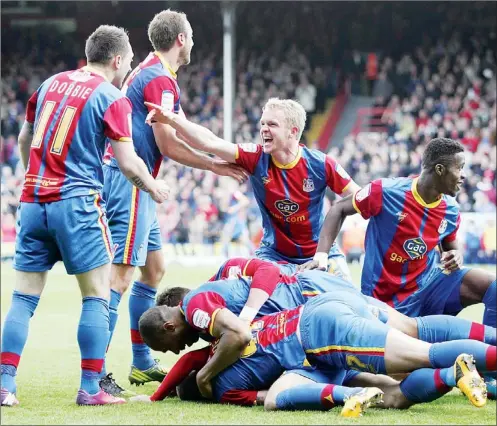  ??  ?? PILE ON: Kevin Phillips, hidden, celebrates with teammates after scoring the second goal for Palace