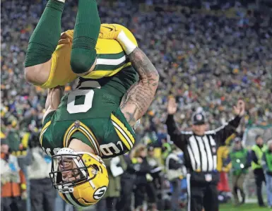  ?? DAN POWERS/ APPLETON (WIS.) POSTCRESCE­NT ?? Packers wide receiver Christian Watson does a back flip in the end zone after scoring on a 58-yard reception in the second quarter against the Cowboys. He finished with three TD receptions.