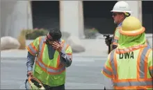  ?? DAVID SWANSON / REUTERS ?? Desert Water Agency workers cool off as the temperatur­e soars in Palm Springs, California, on Wednesday.